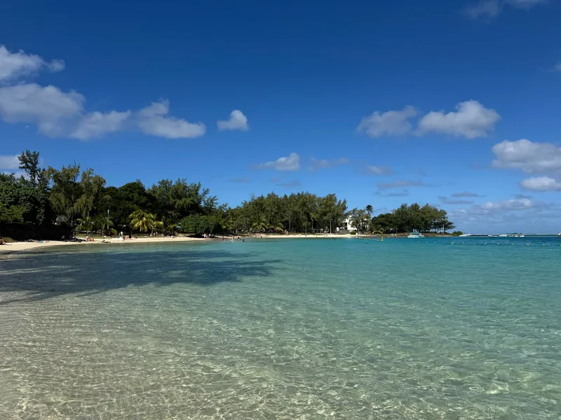 Sonniger Strand und grüne Insel in Blue Bay, Mauritius