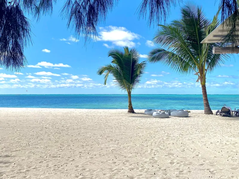Weißer Sandstrand mit Palmen und Liegen auf Mauritius