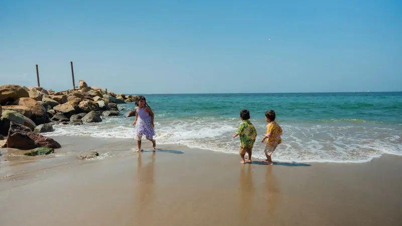 Kinder spielen in den Wellen an einem sonnigen Strand